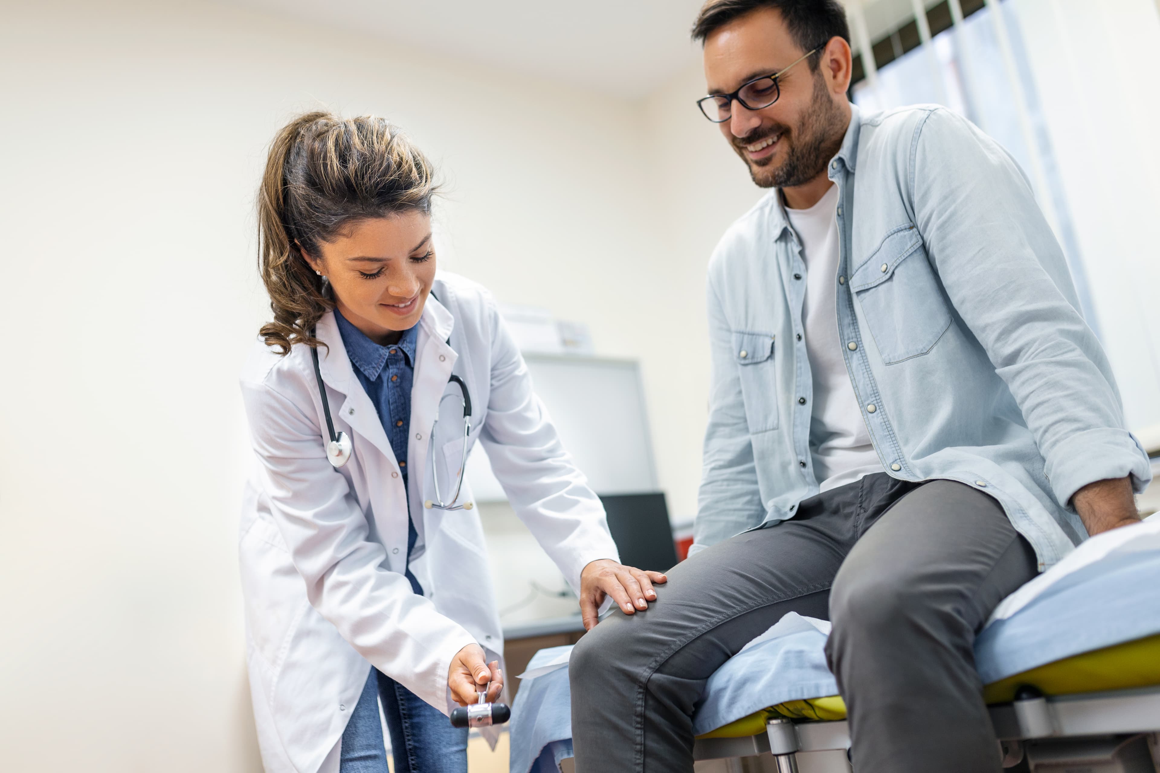 Neurologist testing knee reflex during a neurological examination