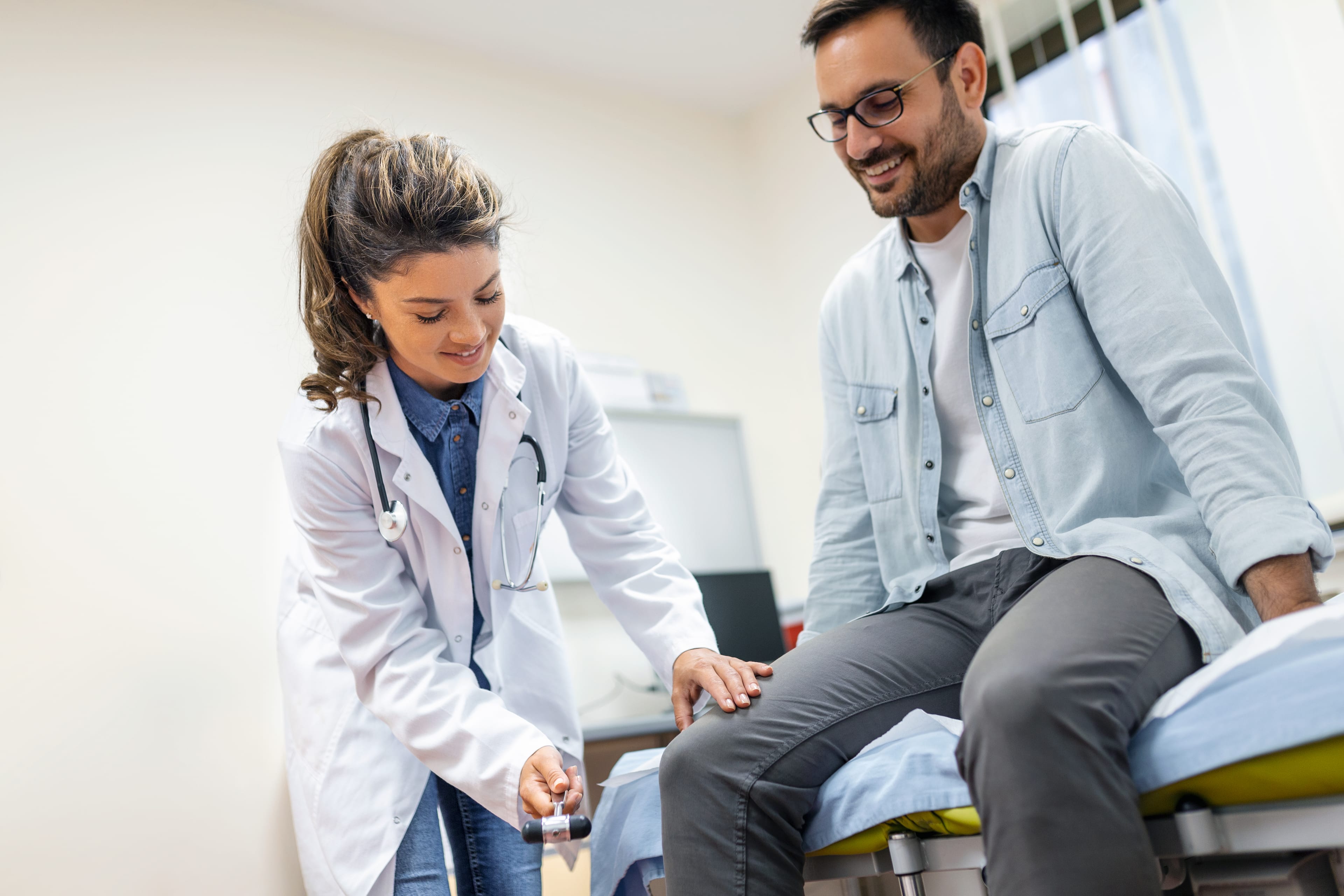 Neurologist testing knee reflex during a neurological examination